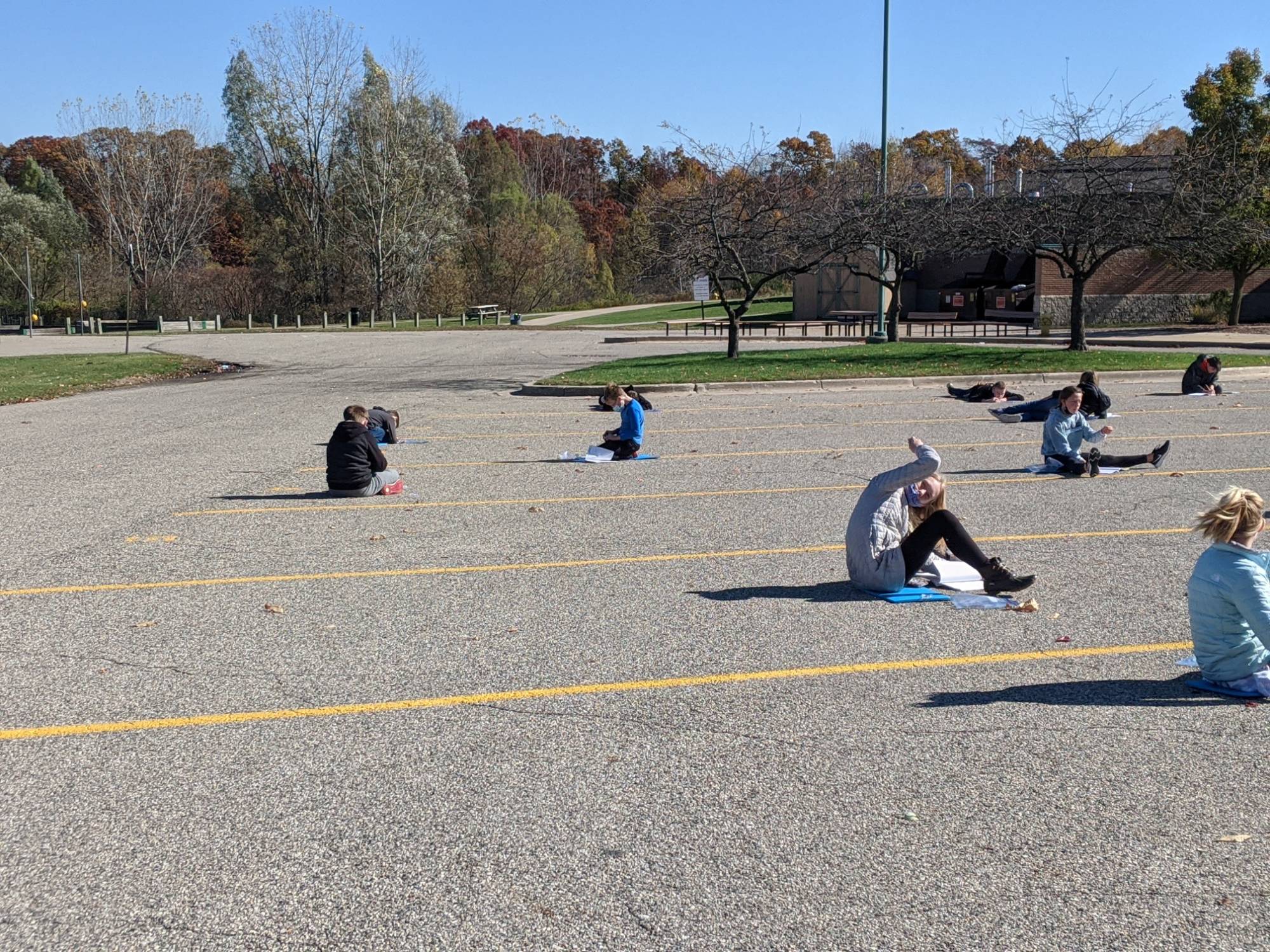 Students sitting on ground in parking lot